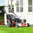The Cobra MX484SPCE self-propelled lawnmower resting on a pristine residential lawn in front of a house