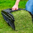 User emptying fresh grass clippings from the Cobra MX484SPCE's large fabric collection bag