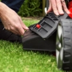 User attaching the side discharge chute onto the Cobra MX484SPCE lawnmower for clearing long grass