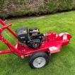 Side view, showing the engine and wheels of the stump grinder.